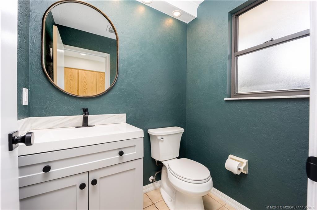 2556 Captiva Cove Stuart, FL 34994 - Photo 57 of 68 a bathroom with a toilet a sink and mirror