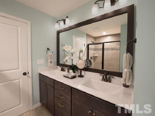 409 Diversity Way Raleigh, NC 27610 - Photo 8 of 13 a bathroom with a double vanity sink and mirror