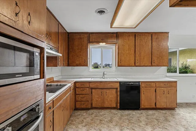 a bathroom with a granite countertop sink toilet and mirror