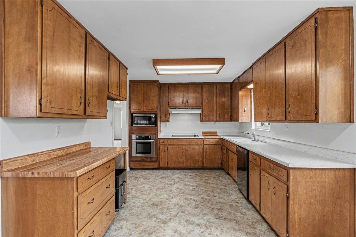 2679 Lobo Avenue Merced, CA 95348 - Photo 27 of 88 a kitchen with stainless steel appliances granite countertop lots of counter top space and wooden floor