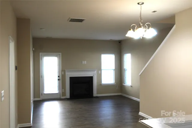 a view of a livingroom with a fireplace wooden floor and windows