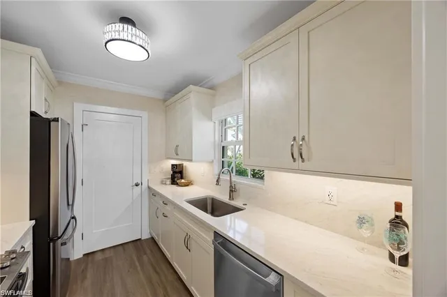 a kitchen with stainless steel appliances a stove a sink a refrigerator and cabinets