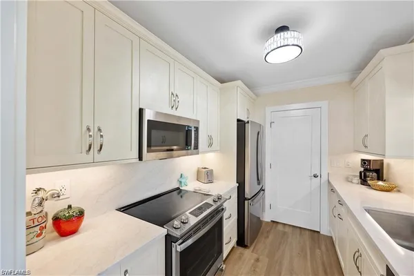 a kitchen with stainless steel appliances a stove a sink and a microwave