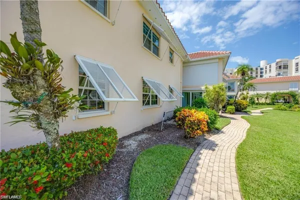 a front view of a house with garden and trees