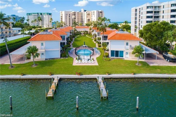 an aerial view of a house with a garden and lake view