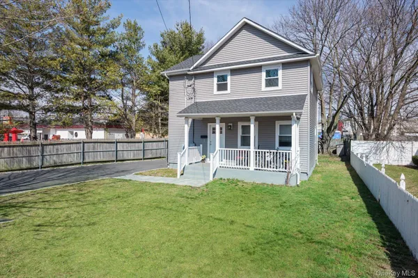 a view of house with yard and deck
