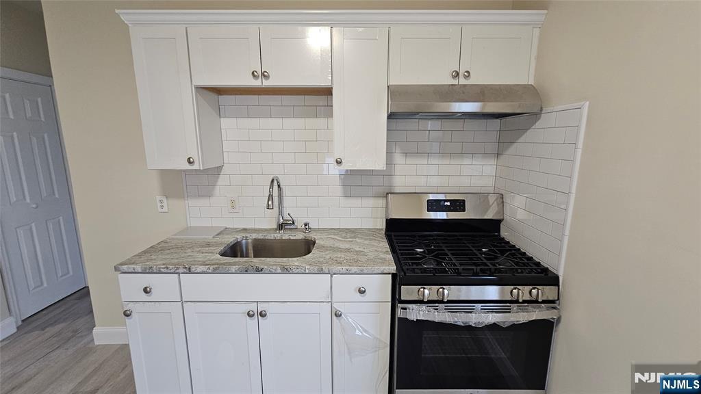 164 Humboldt Street East Rutherford, NJ 07073 - Photo 5 of 12 a kitchen with white cabinets and appliances