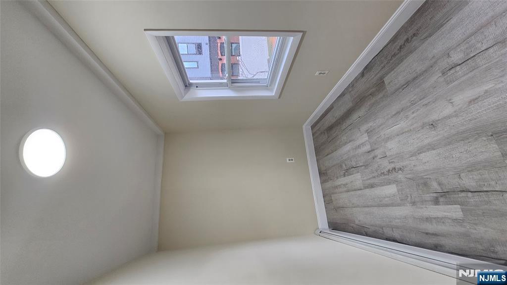 164 Humboldt Street East Rutherford, NJ 07073 - Photo 7 of 12 an empty room with wooden floor and windows