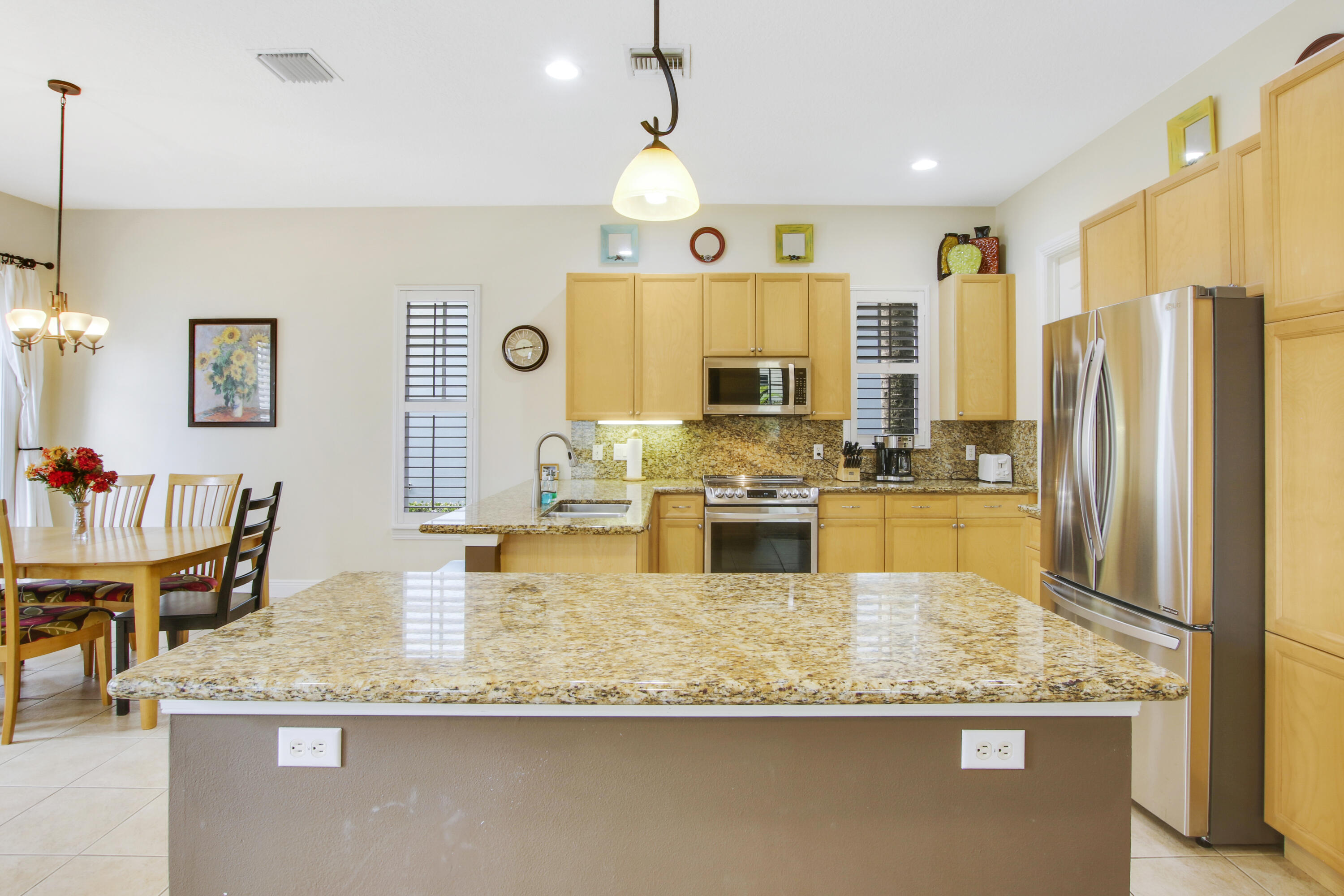 108 Spikerush Road Jupiter, FL 33458 - Photo 4 of 9 a large kitchen with granite countertop a stove and white cabinets