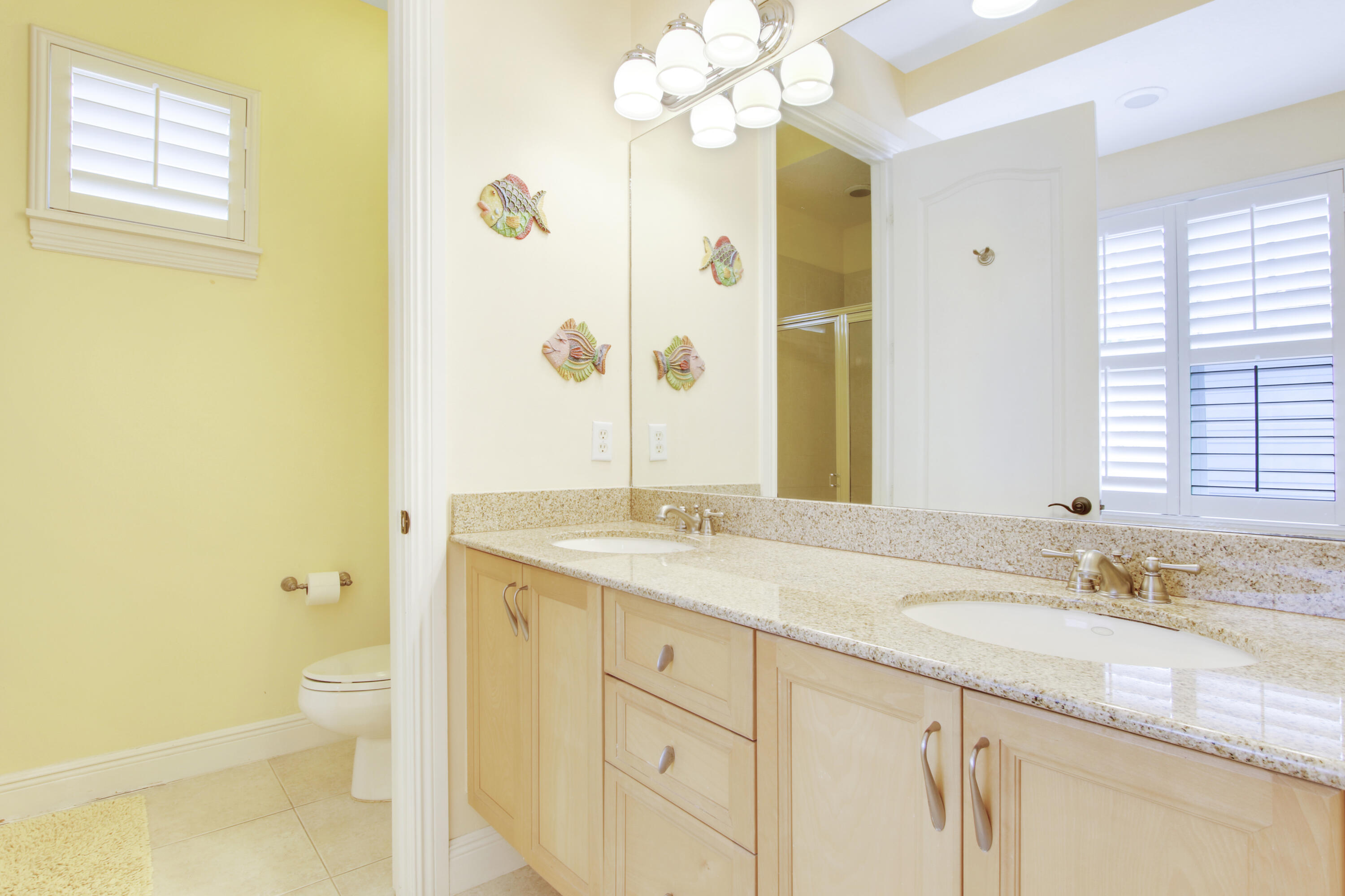 108 Spikerush Road Jupiter, FL 33458 - Photo 6 of 9 a bathroom with a granite countertop sink a toilet and a mirror