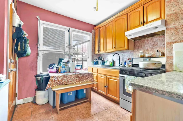 a kitchen with stainless steel appliances granite countertop a stove a sink and a microwave