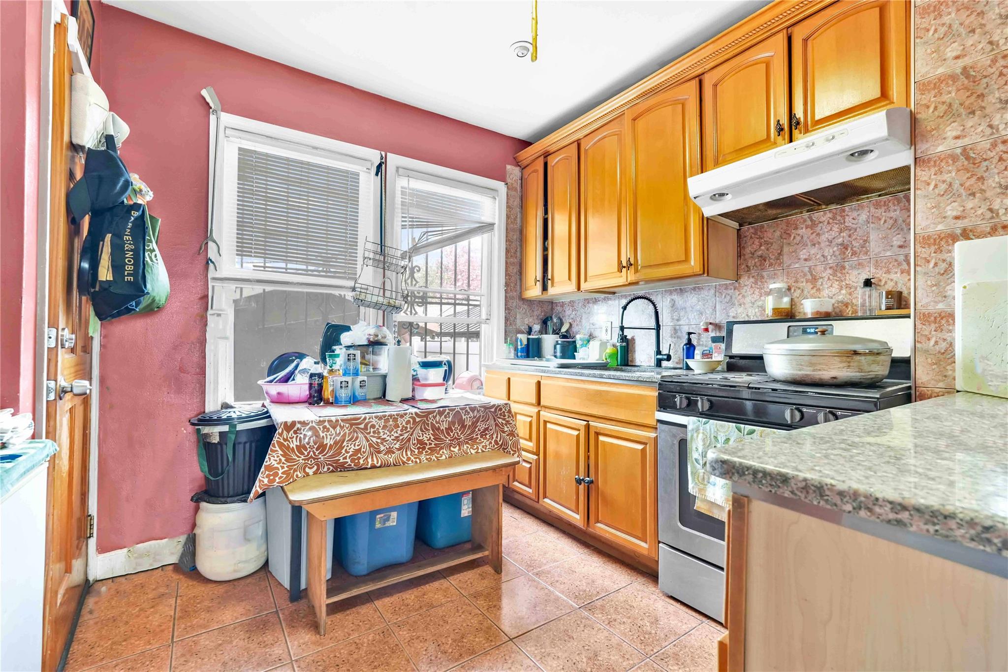 104-55 128th Street Queens, NY 11419 - Photo 3 of 12 a kitchen with stainless steel appliances granite countertop a stove a sink and a microwave