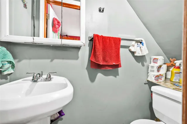 a bathroom with a sink toilet and a mirror