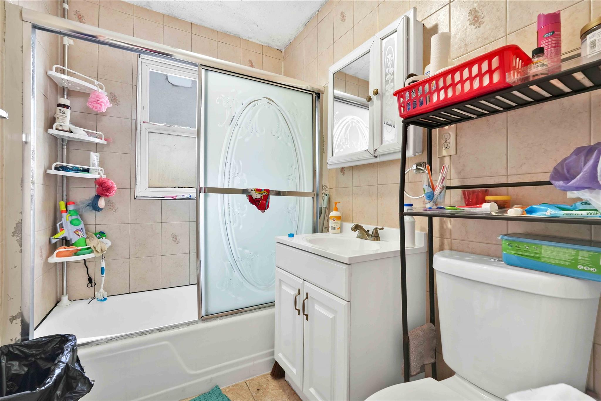 104-55 128th Street Queens, NY 11419 - Photo 5 of 12 a bathroom with a sink a toilet and shower curtain