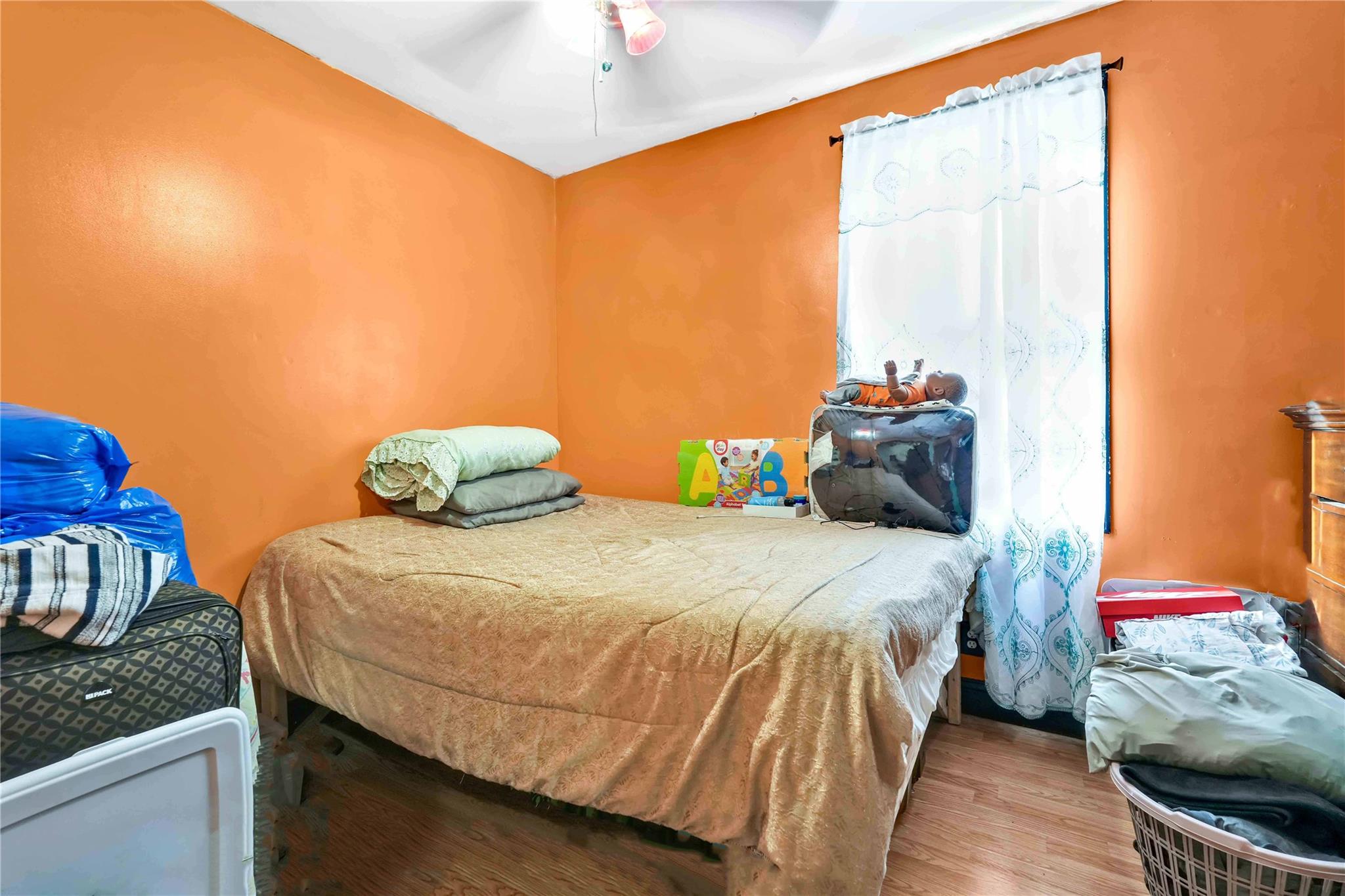 104-55 128th Street Queens, NY 11419 - Photo 7 of 12 a bedroom with a bed and wooden floor