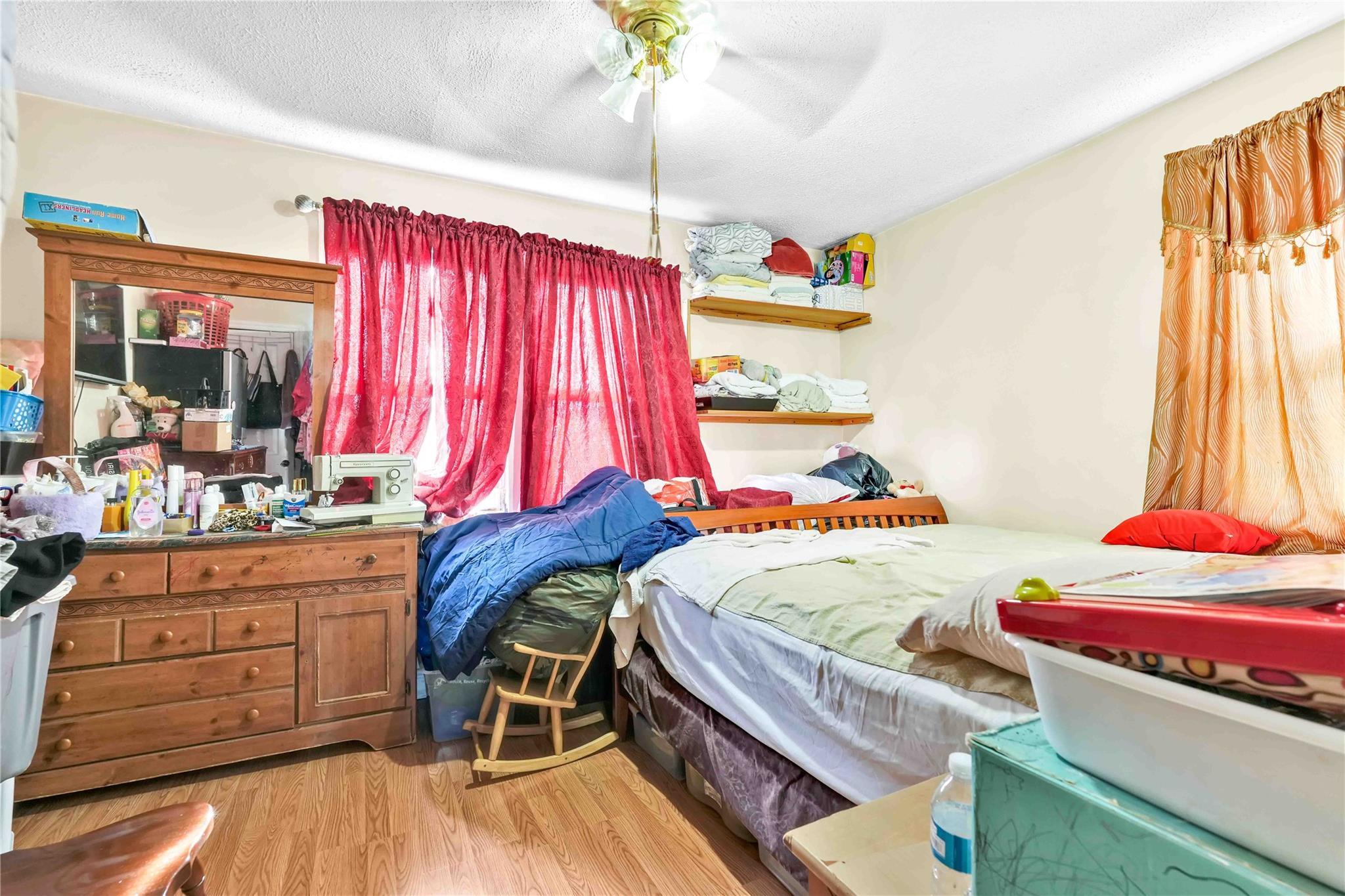 104-55 128th Street Queens, NY 11419 - Photo 9 of 12 a bedroom with a bed and a dresser