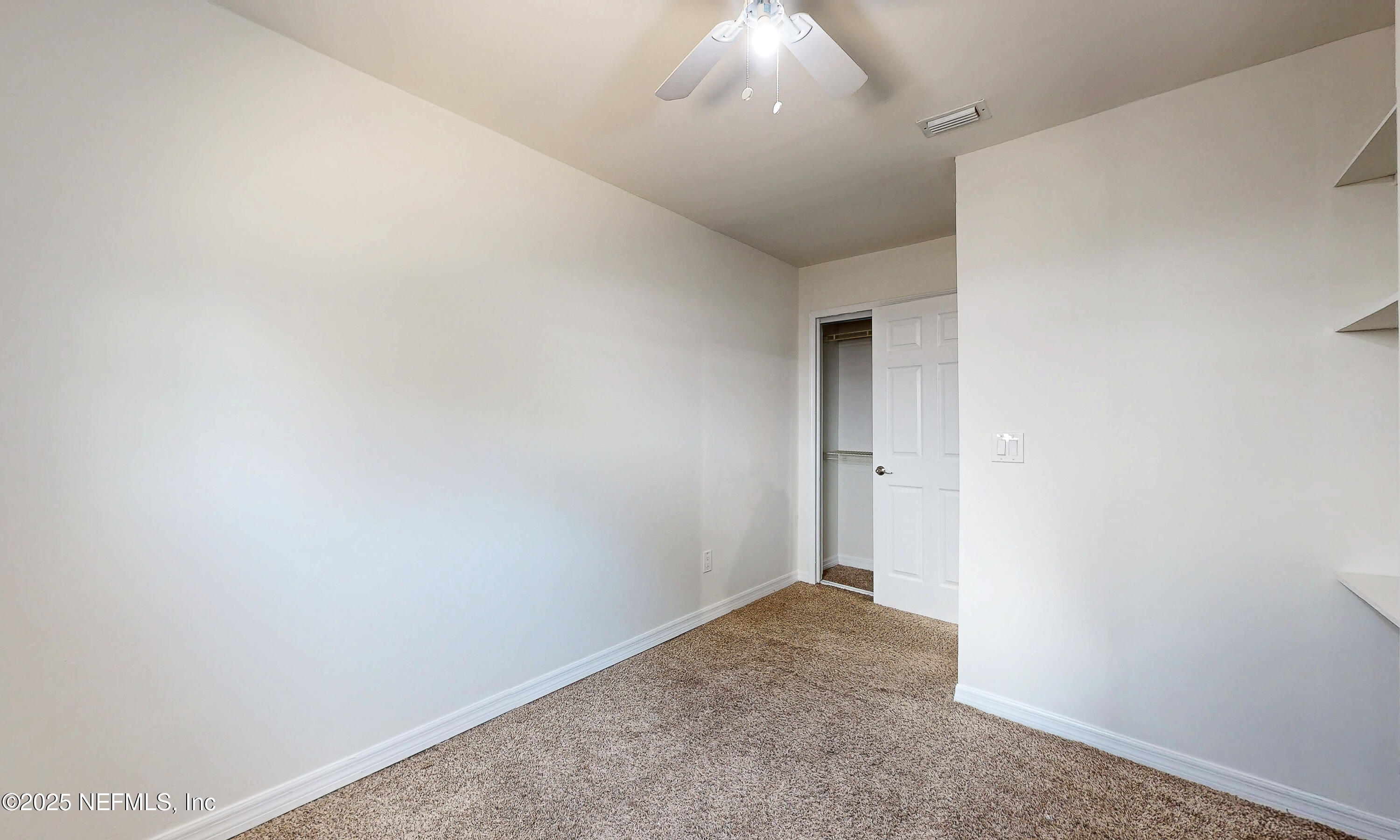 6433 River Point Drive Fleming Island, FL 32003 - Photo 32 of 76 an empty room with a chandelier fan and wooden floor