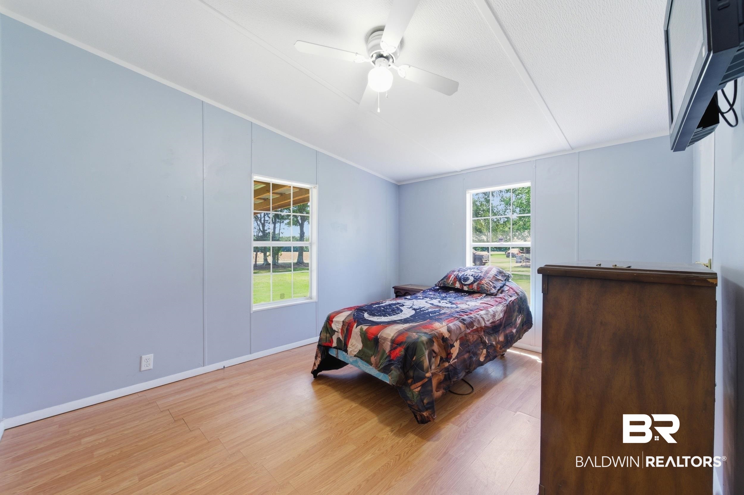 926 Tumbling Lane Atmore, AL 36502 - Photo 35 of 56 Interior room with wood-finish flooring and light blue panel walls