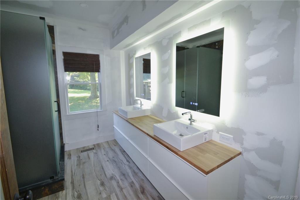 3431 Lee Moore Road Maiden, NC 28650 - Photo 21 of 44 a bathroom with a sink a mirror and a bathtub