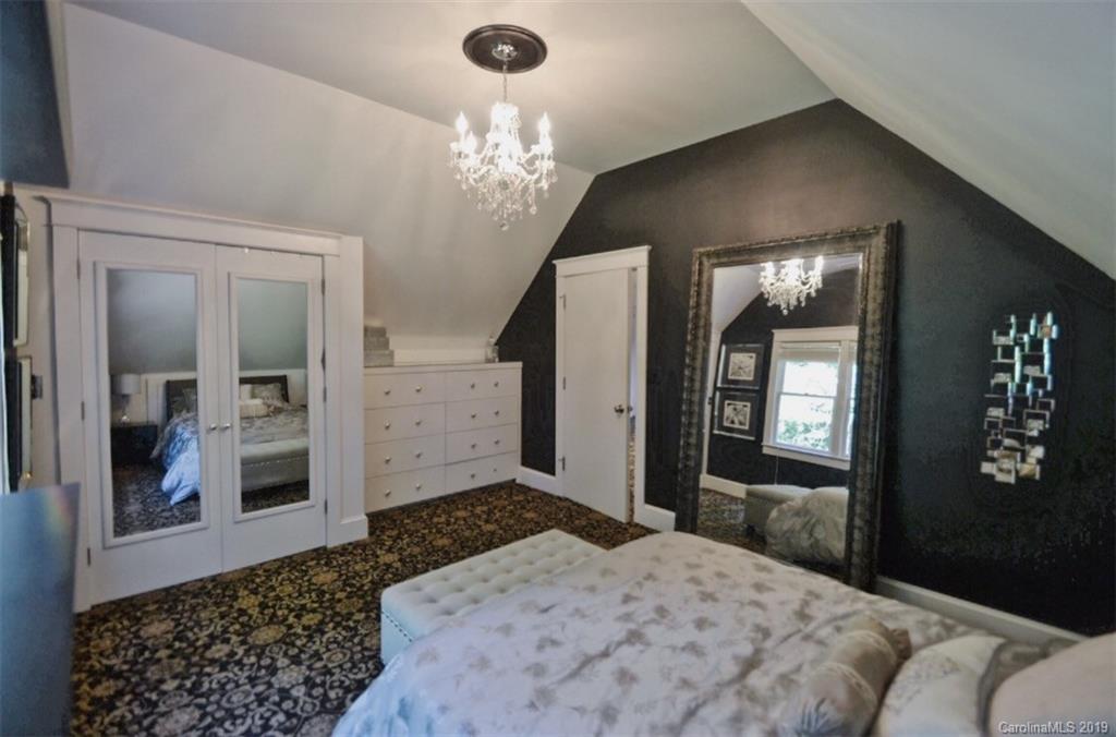 3431 Lee Moore Road Maiden, NC 28650 - Photo 32 of 44 a bedroom with a large bed and a chandelier