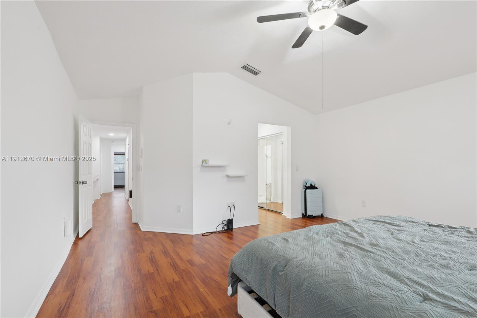 14804 Southwest 155th Place Miami, FL 33196 - Photo 26 of 35 a spacious bedroom with a bed and a chandelier