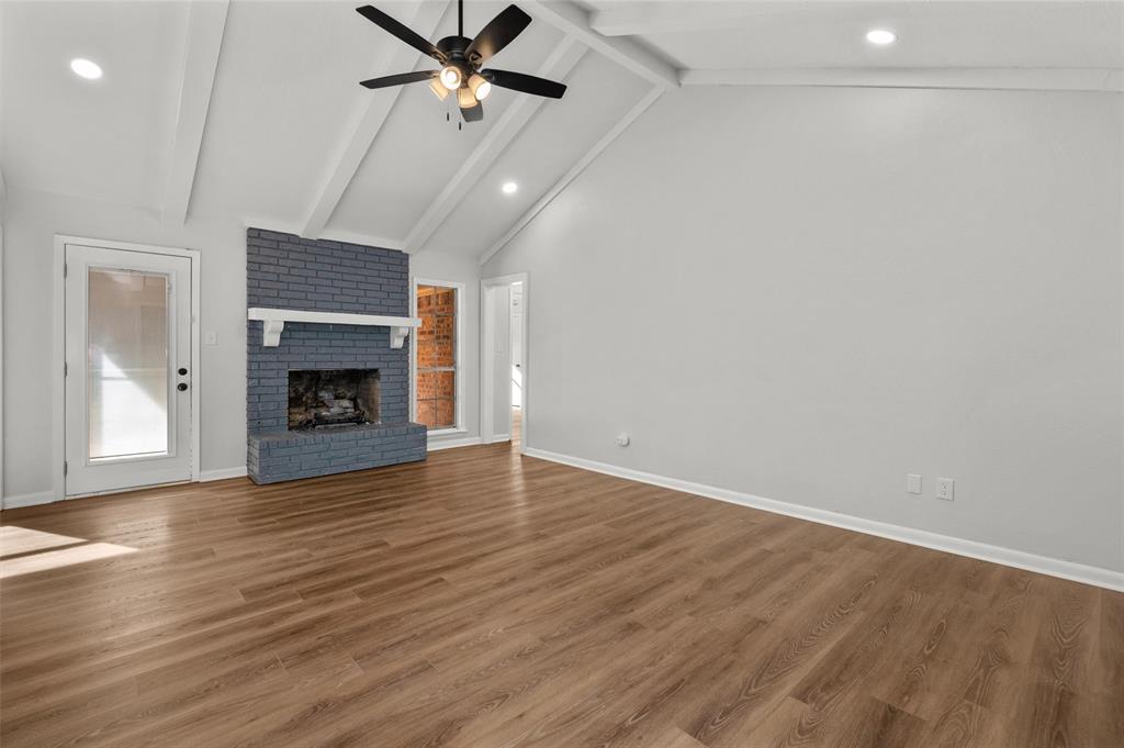 809 Princesa Drive Haughton, LA 71037 - Photo 5 of 17 an empty room with wooden floor a fireplace and a ceiling fan