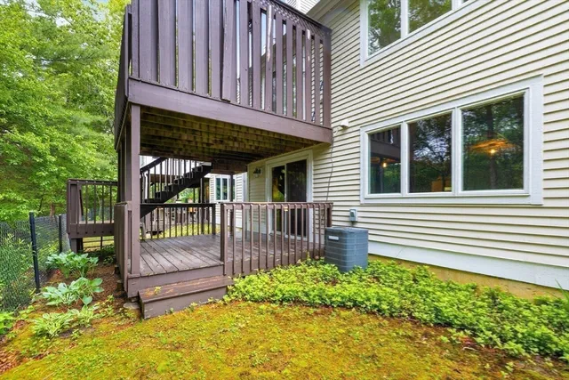 a view of a house with a small yard and wooden floor and fence
