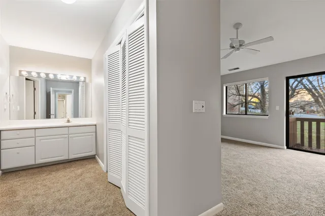 a bathroom with a granite countertop sink mirror and window