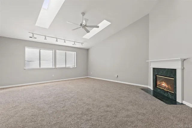 an empty room with windows and fireplace