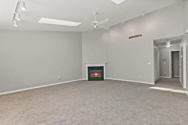 a view of an empty room with a fireplace and a fan