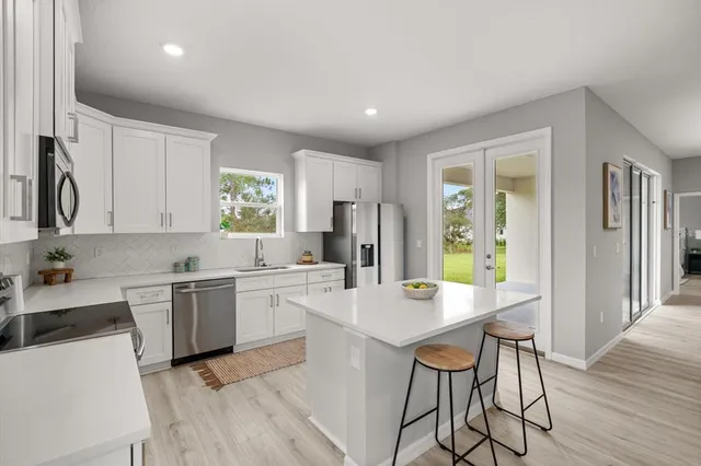 a kitchen with a dining table chairs and refrigerator