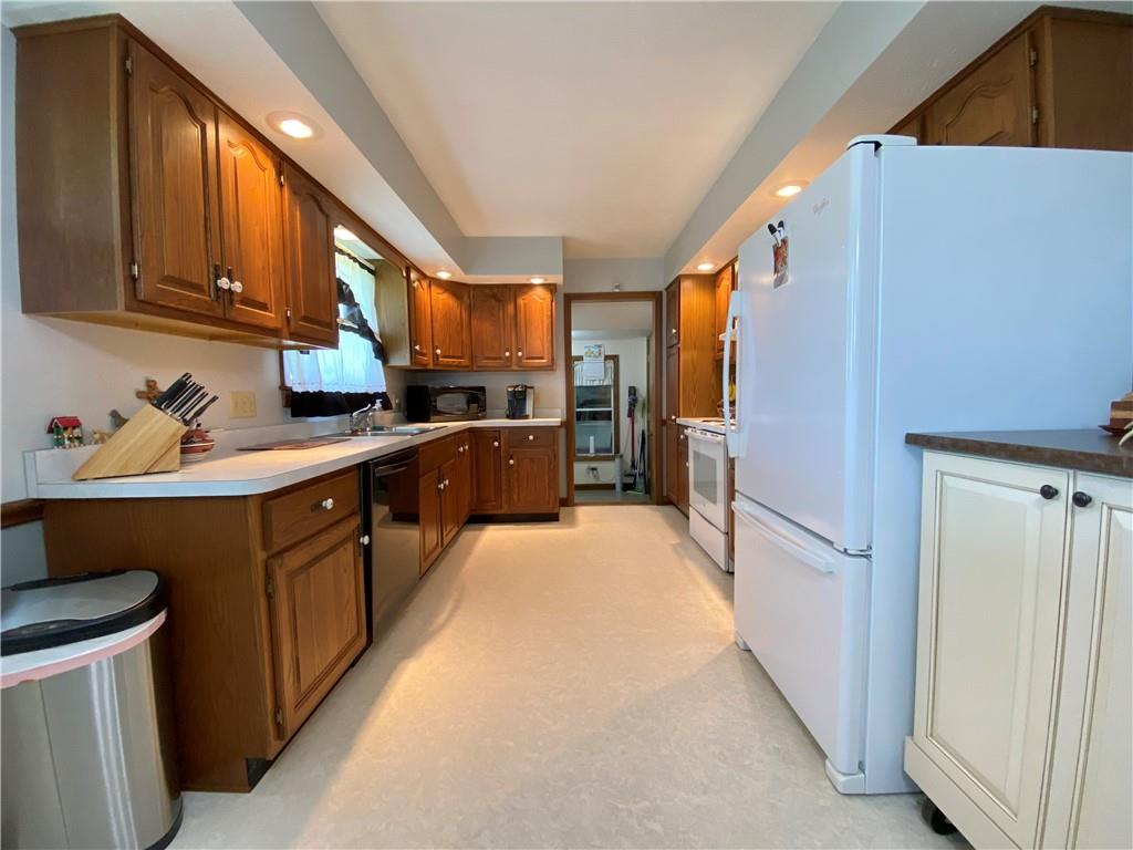 240 Hamburg Road Greenville, PA 16125 - Photo 24 of 46 a kitchen with stainless steel appliances granite countertop a refrigerator a sink dishwasher a stove with wooden cabinets
