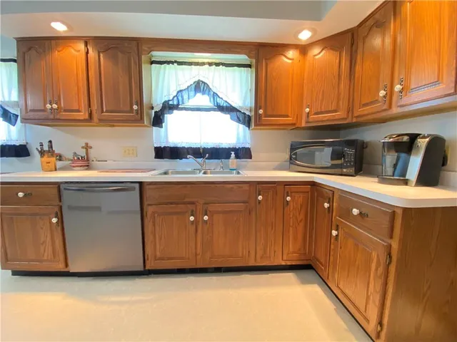 a kitchen with a sink window and cabinets