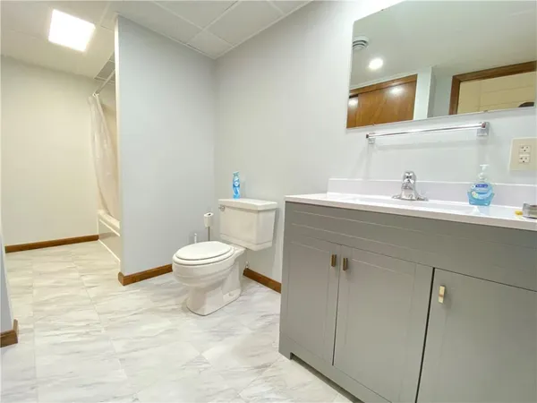 a bathroom with a toilet a sink and a mirror