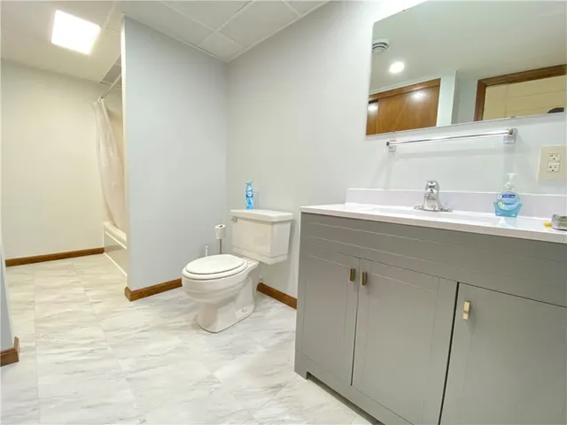 a bathroom with a toilet a sink and a mirror