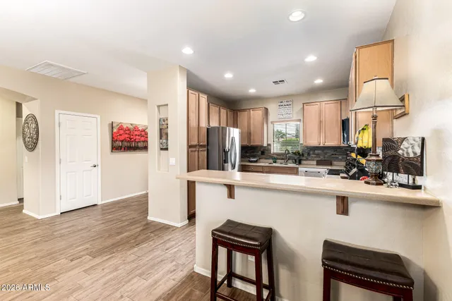 a kitchen with stainless steel appliances granite countertop a sink cabinets and wooden floor
