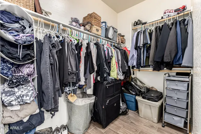 a view of walk in closet with clothes and shoes