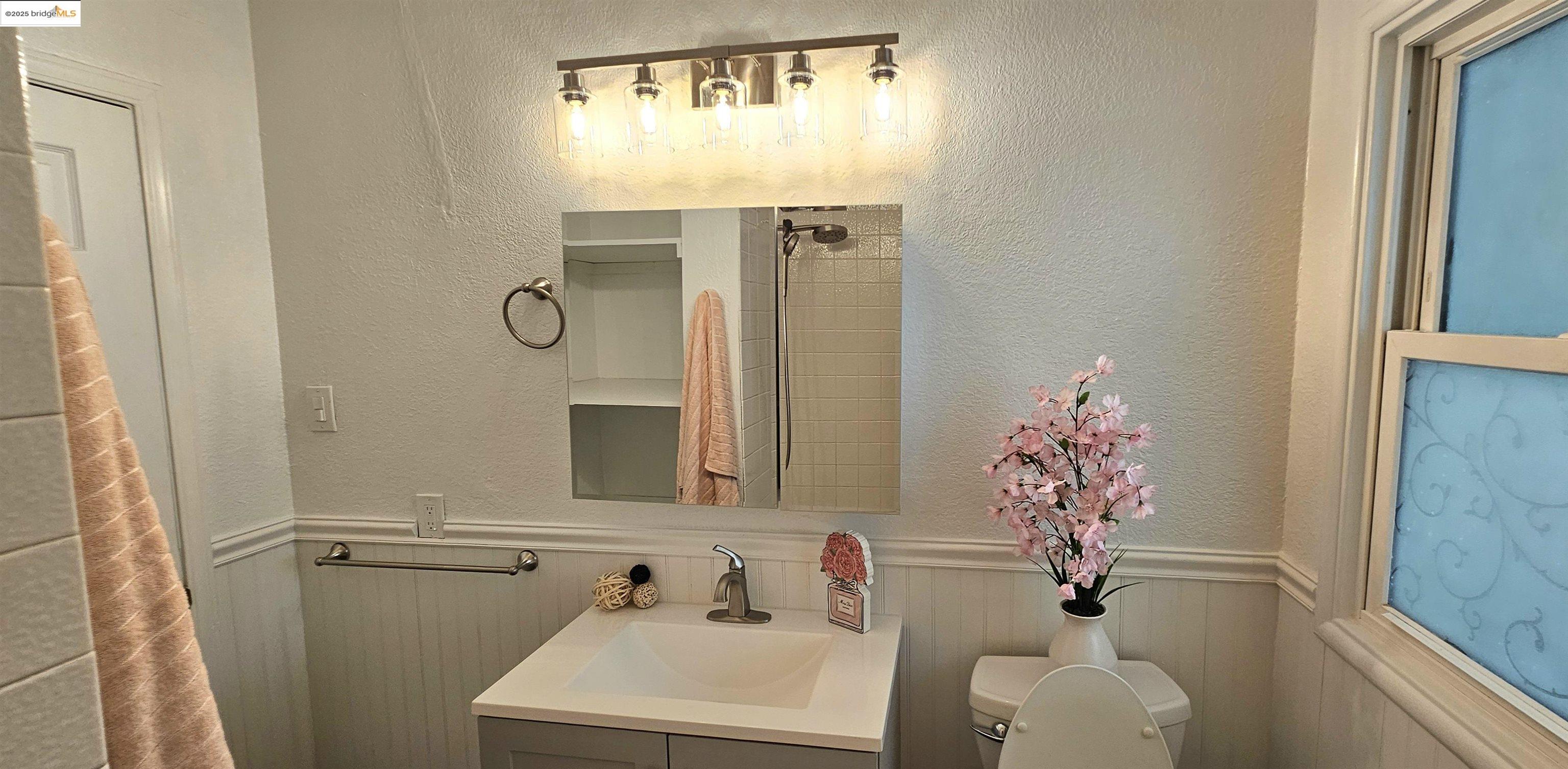 3195 Willow Pass Road Concord, CA 94519 - Photo 16 of 30 a bathroom with a sink and mirror with toilet