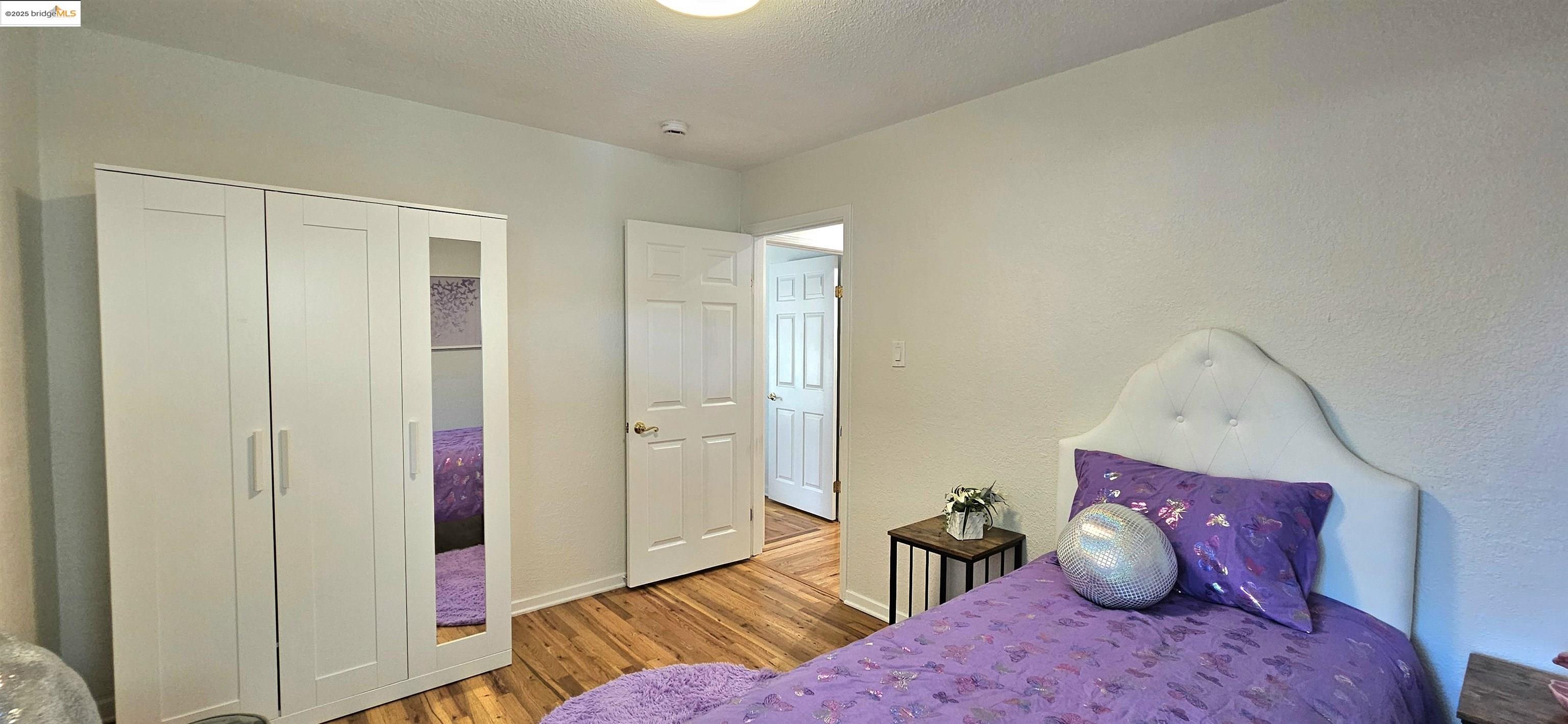 3195 Willow Pass Road Concord, CA 94519 - Photo 21 of 30 a bedroom with a bed and wooden floor