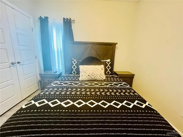 a bed sitting in a bedroom next to a wooden cabinet