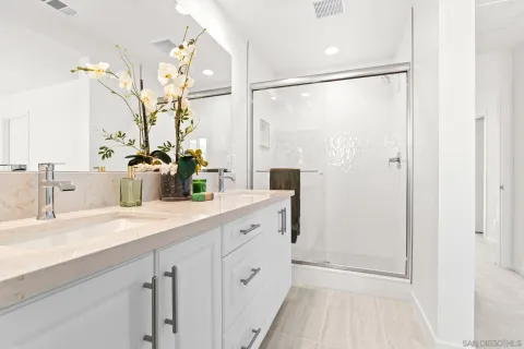 a spacious bathroom with a double vanity sink mirror and shower