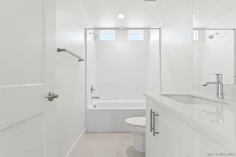 a bathroom with a granite countertop sink a toilet and shower