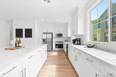 a large white kitchen with stainless steel appliances granite countertop lots of counter top space and cabinets