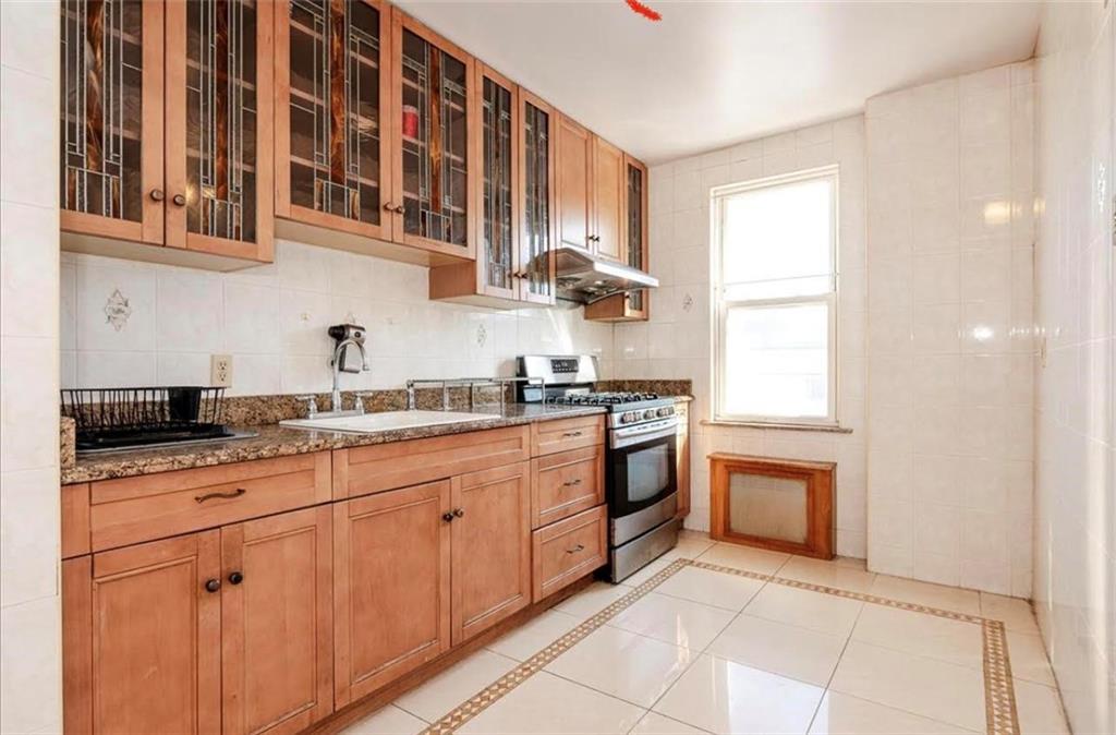 1722 Ave V Brooklyn, NY 11229 - Photo 14 of 28 a kitchen with stainless steel appliances granite countertop a sink and dishwasher a stove top oven with wooden floor