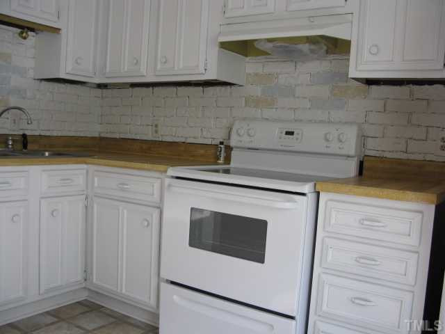 813 Green Ridge Drive Raleigh, NC 27609 - Photo 6 of 22 a kitchen with granite countertop white cabinets and white appliances