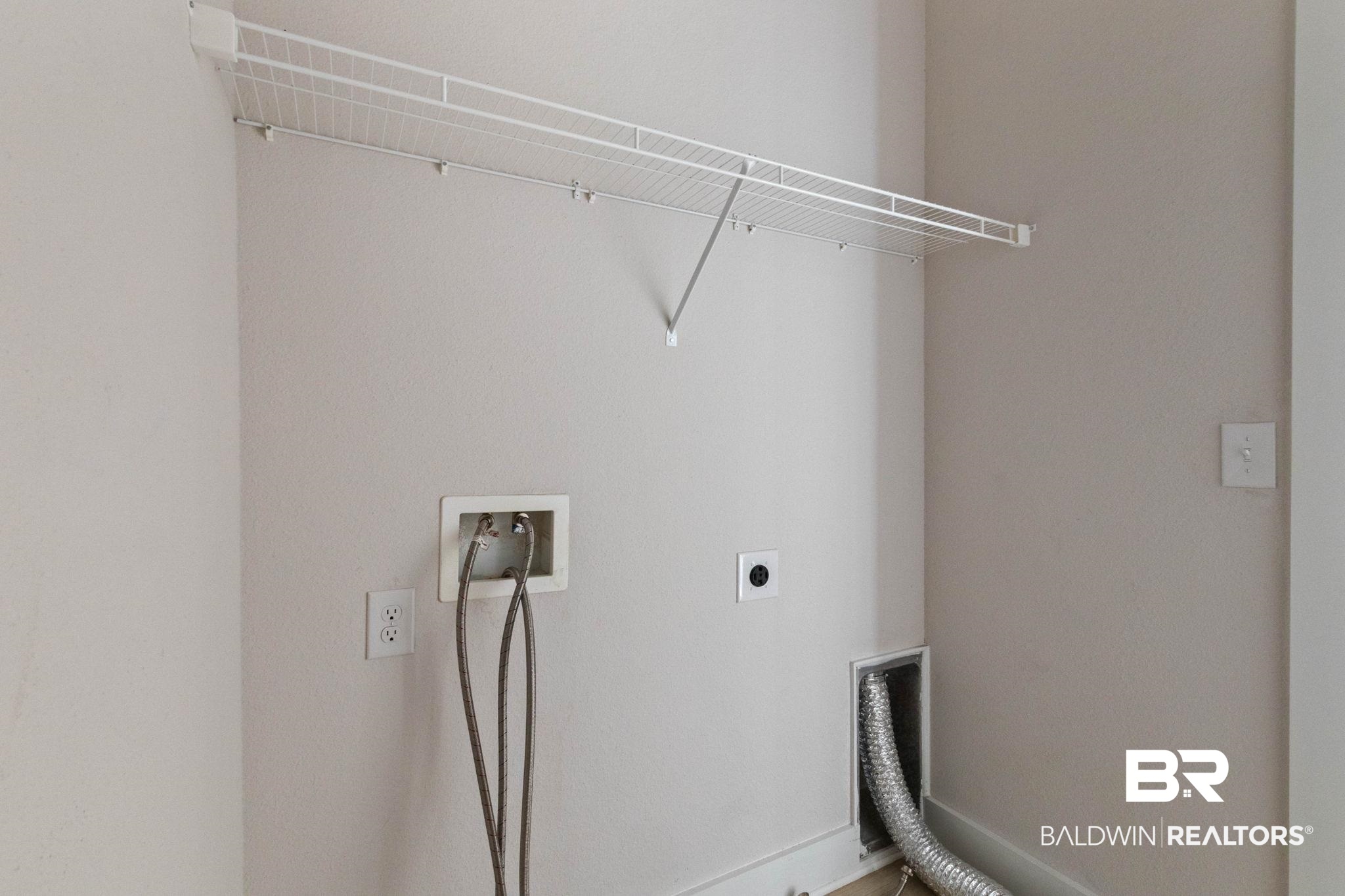 1710 Grouse Street Foley, AL 36535 - Photo 47 of 76 Dedicated laundry area featuring a white wire shelving unit, appliance hookups, and a dryer vent