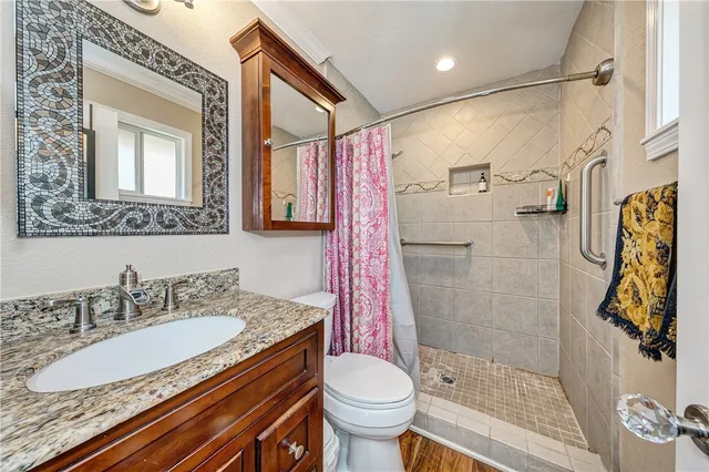 a bathroom with a granite countertop sink toilet and shower