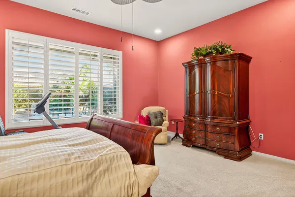 a bedroom with a bed and a potted plant