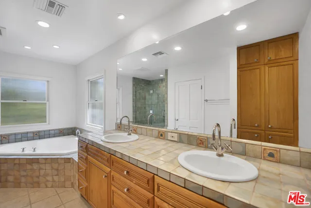 a bathroom with a granite countertop sink and a bathtub