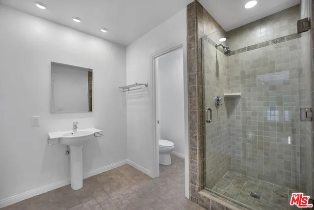 a bathroom with a sink a toilet and shower